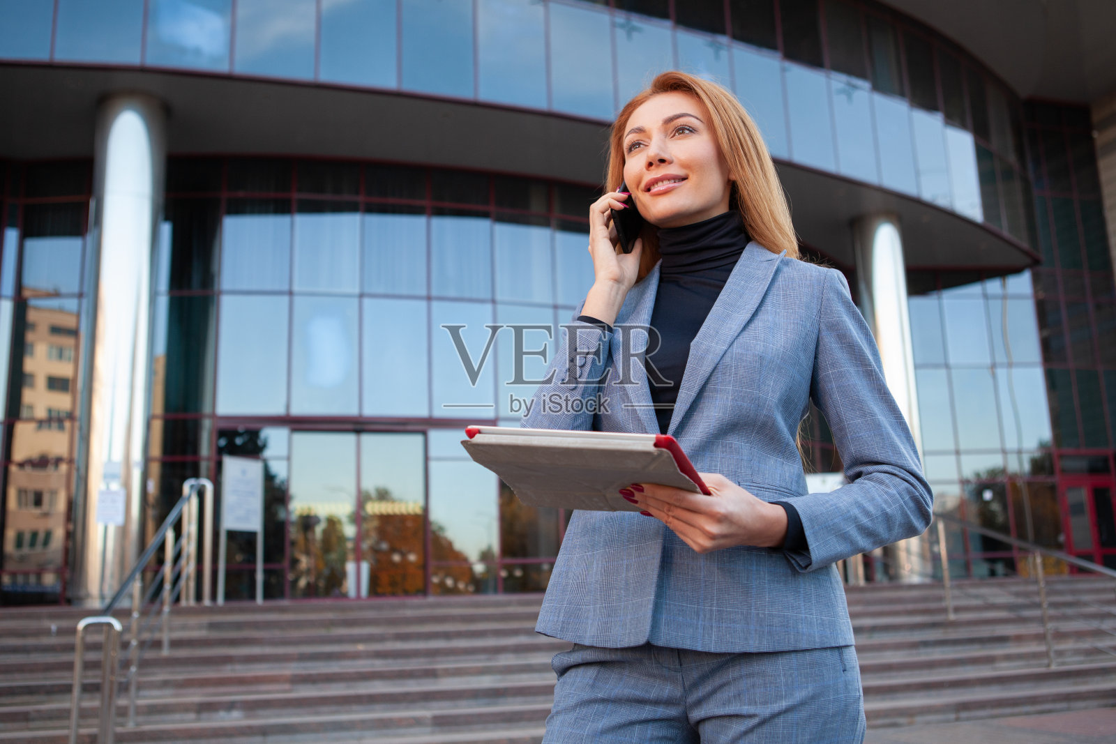 有魅力的女商人站在办公楼前照片摄影图片