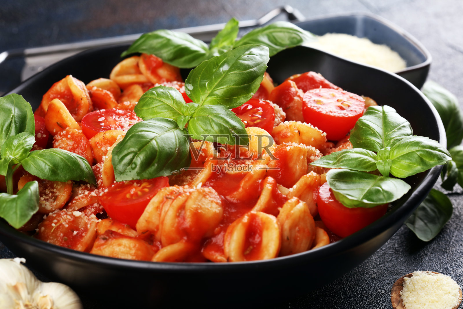 面食orecchiette。一盘美味的耳朵酱，配以帕尔玛干酪和罗勒，以乡村风味为背景照片摄影图片