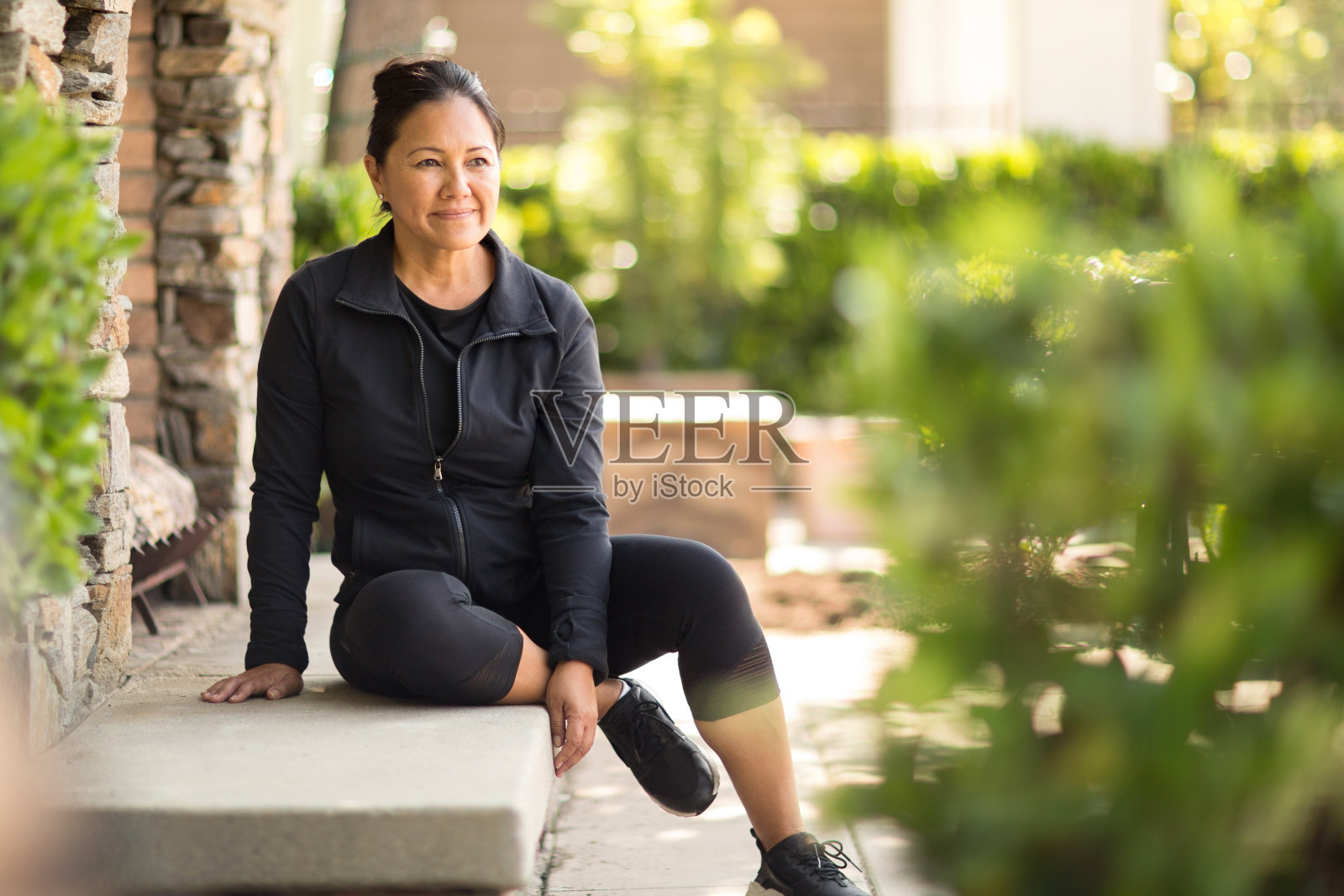 一个健康的亚洲女人坐在外面思考。照片摄影图片