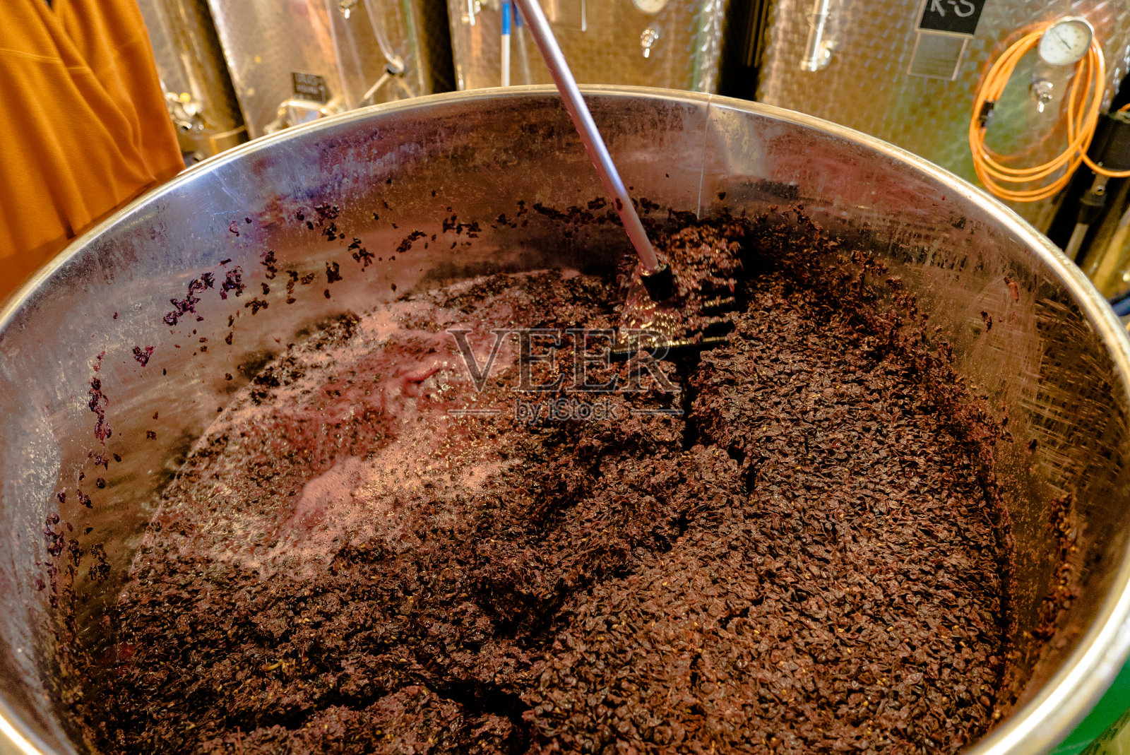 在酿酒过程中，将黑皮诺葡萄在一个开放的容器中搅拌和混合照片摄影图片