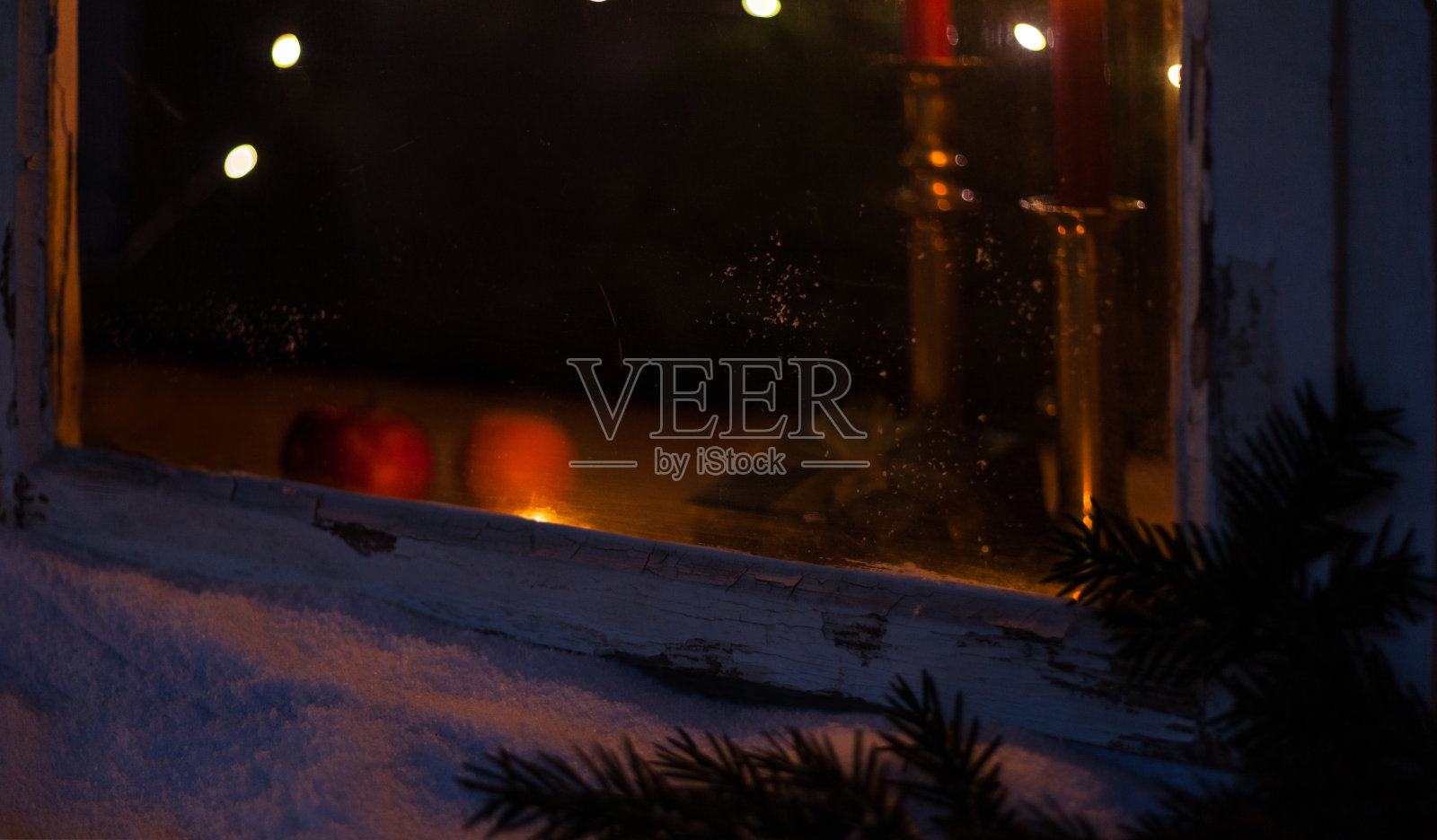 在冬天看着圣诞的窗户里燃着蜡烛照片摄影图片