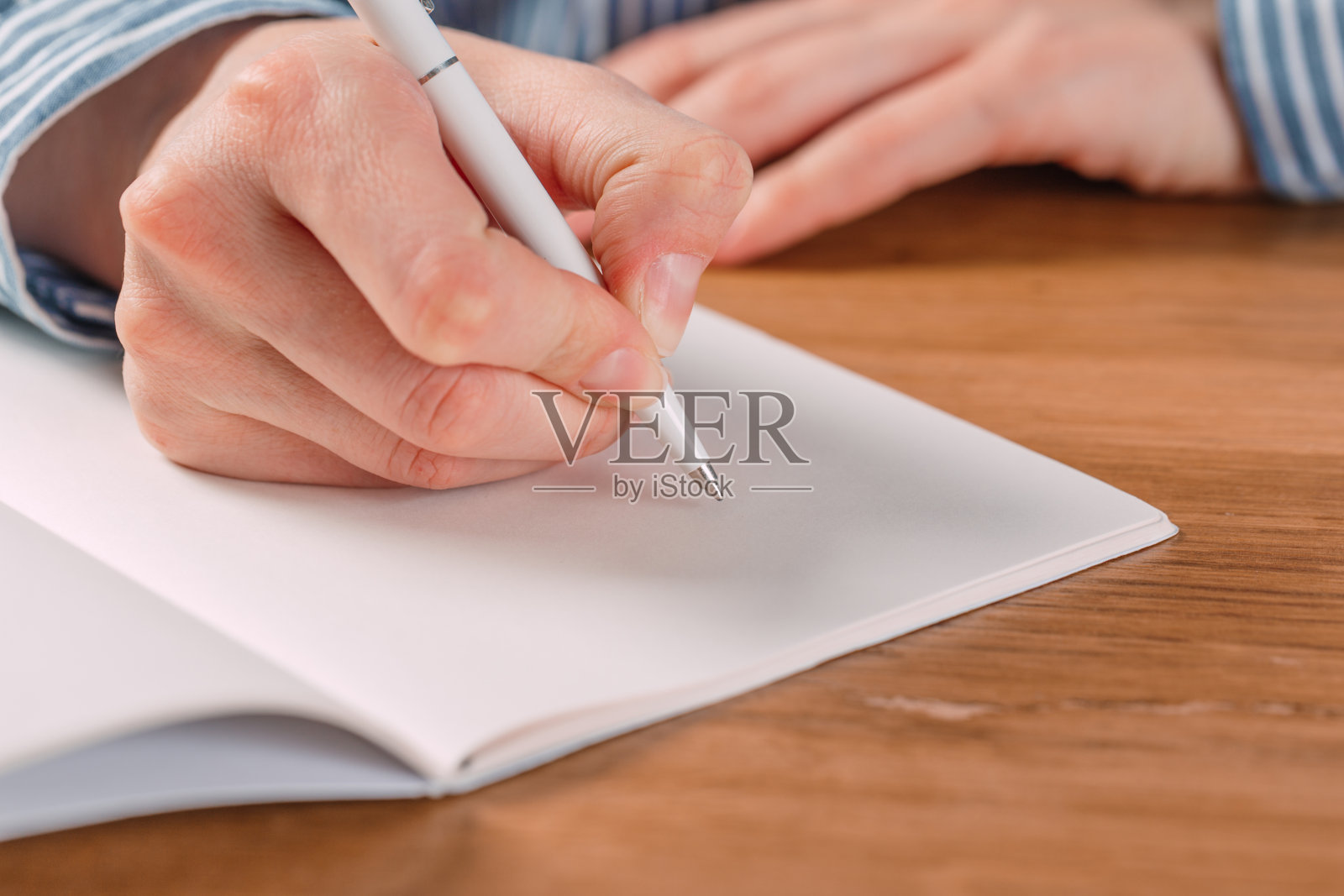 美丽女性的手写在笔记本上的任务和目标的工作桌上照片摄影图片