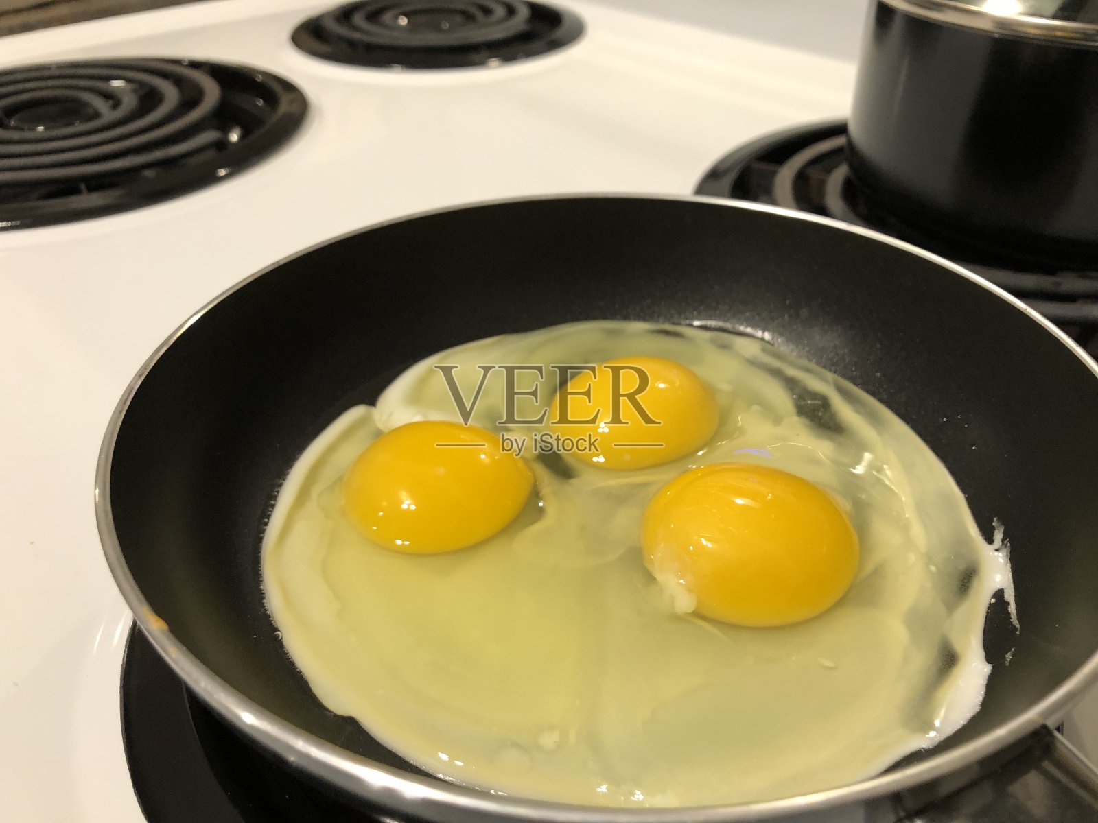 3个鸡蛋在平底锅里煮熟照片摄影图片