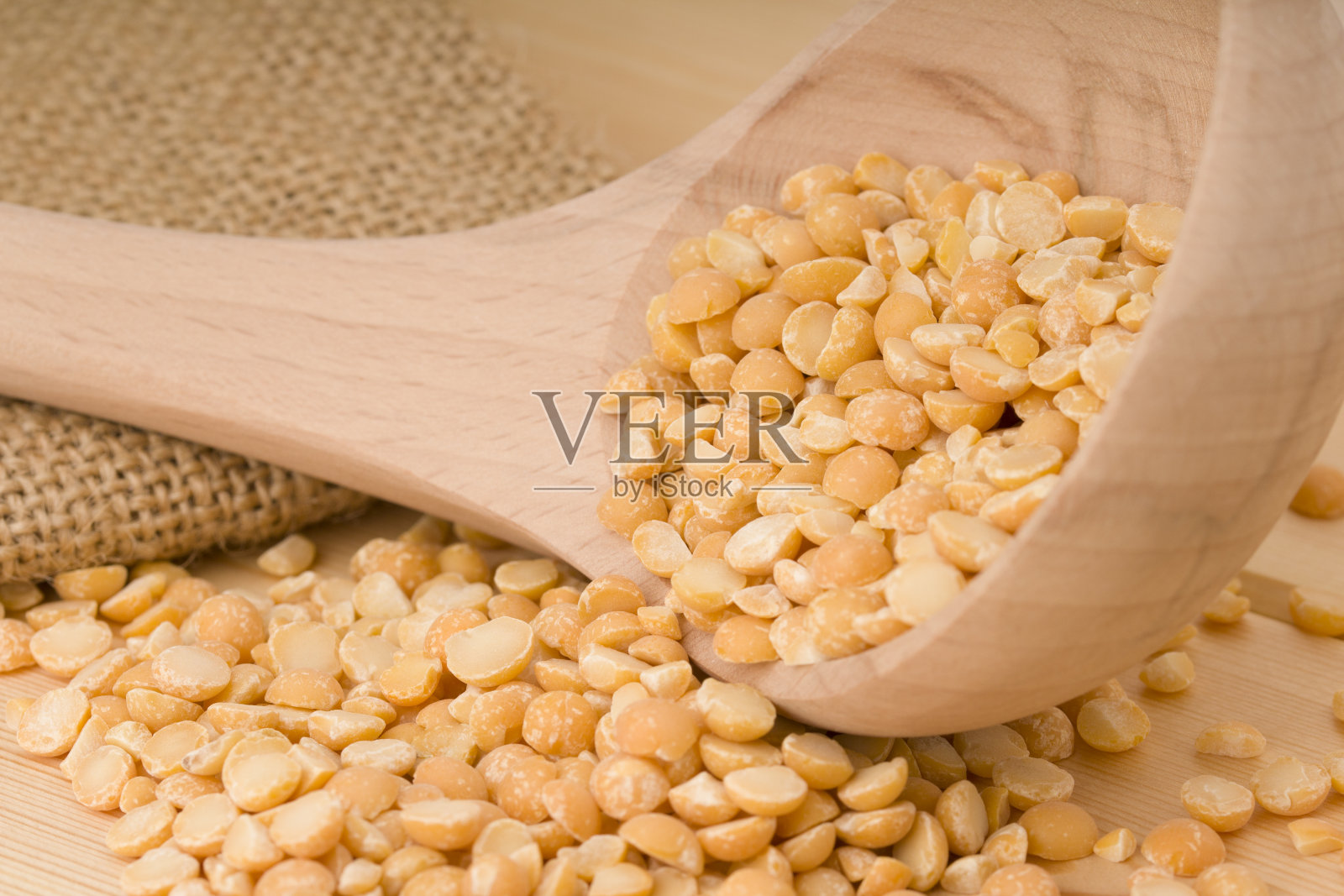 用木勺舀干豌豆，健康食品。照片摄影图片