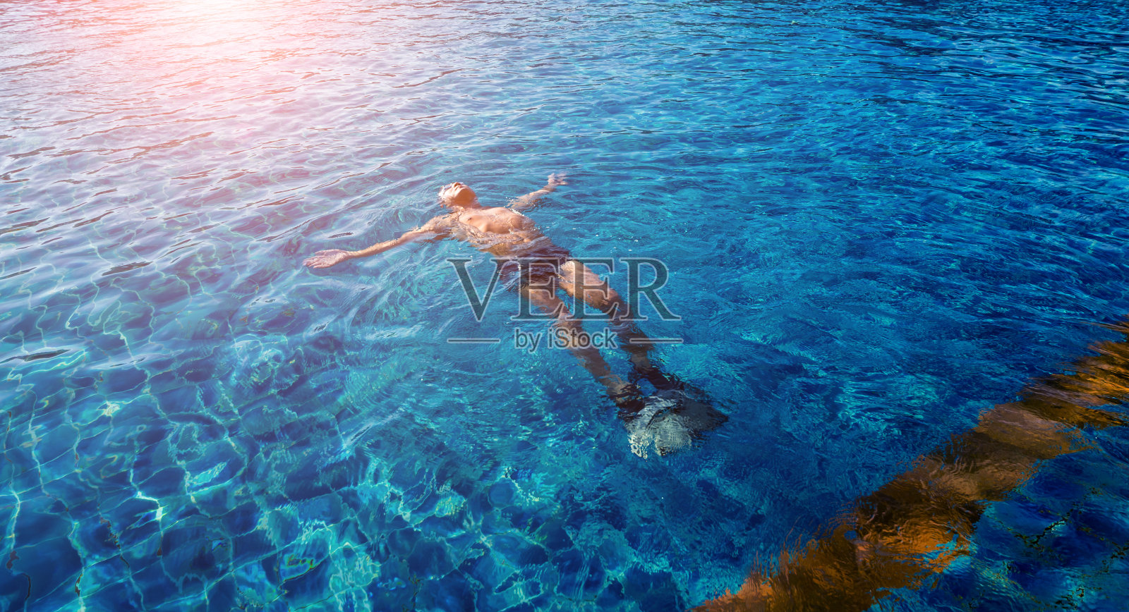 一个年轻的运动员在游泳池里游泳照片摄影图片