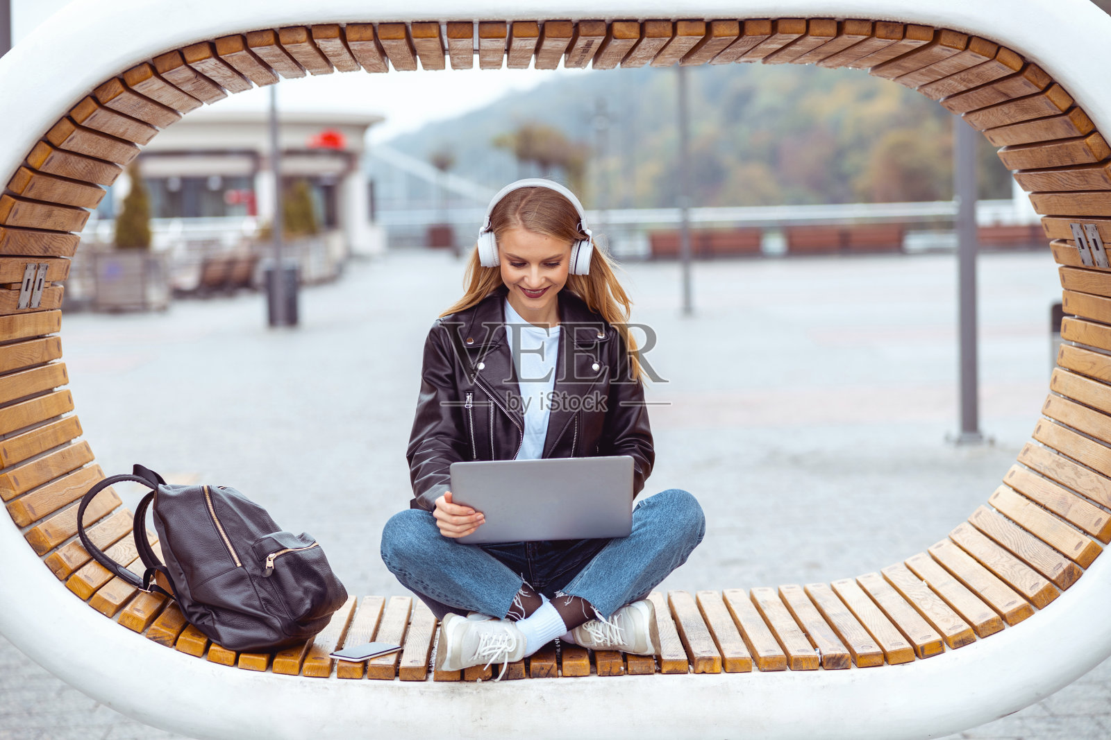 一个拿着电脑对着别人微笑的大忙人照片摄影图片