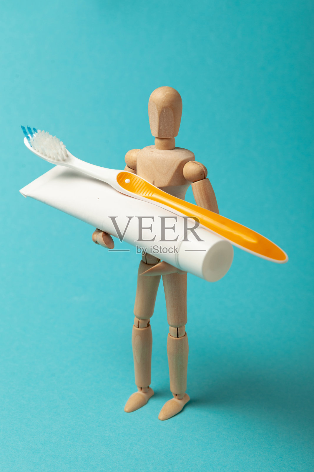 口腔卫生和牙齿护理。木制的人拿着牙刷和牙膏照片摄影图片