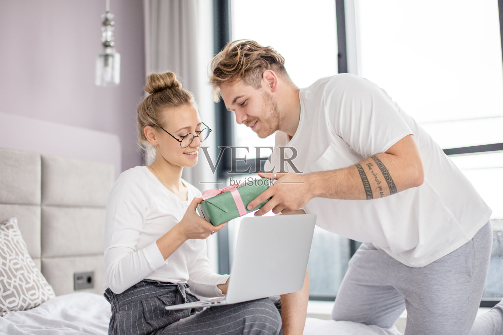 一个白种帅哥正在给他女朋友送礼物照片摄影图片