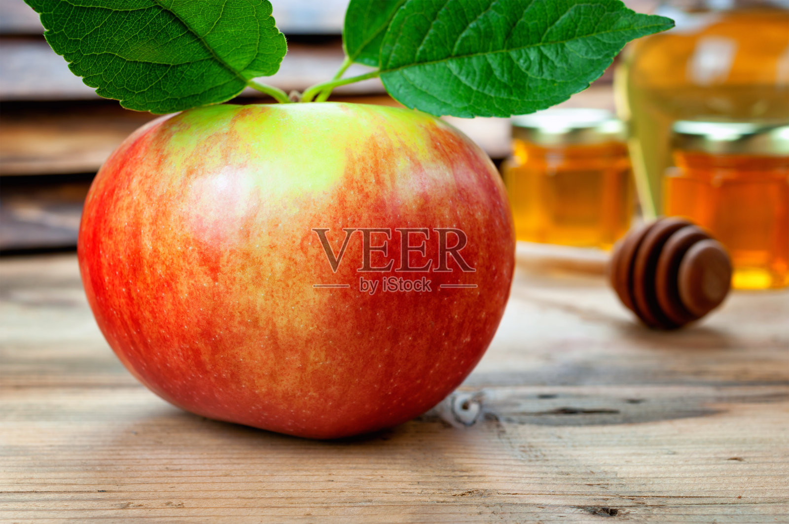 新鲜的苹果和蜂蜜放在木桌上照片摄影图片
