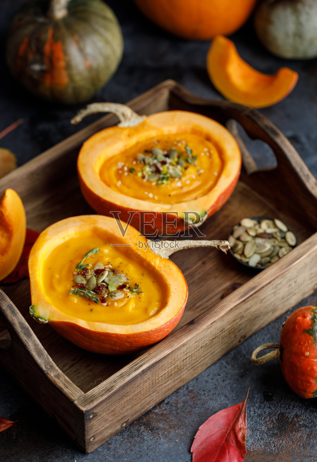 南瓜汤在南瓜里。素食秋南瓜籽奶油汤照片摄影图片