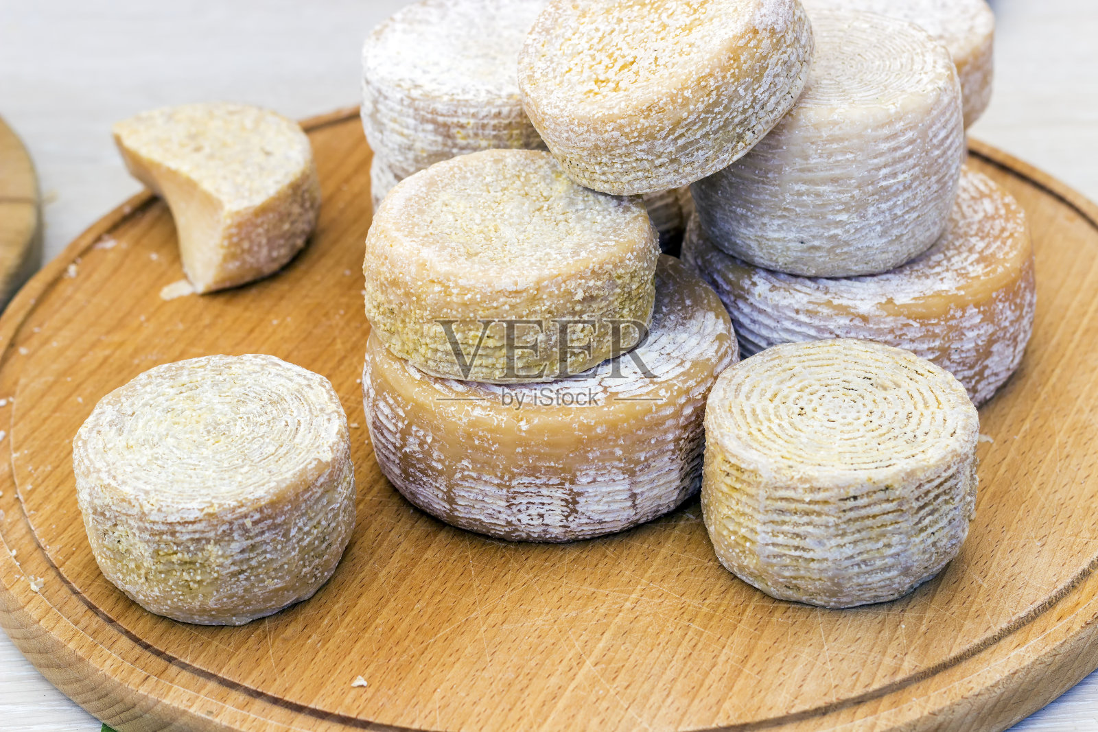 硬质奶酪切在一块木板上，背景是乡村的黑色照片摄影图片