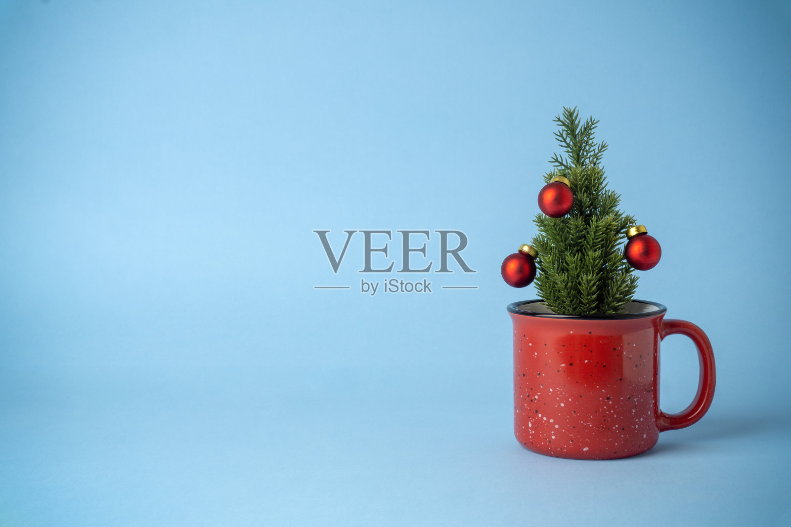 在蓝色背景上有杯形装饰的圣诞树。圣诞假期饮料照片摄影图片