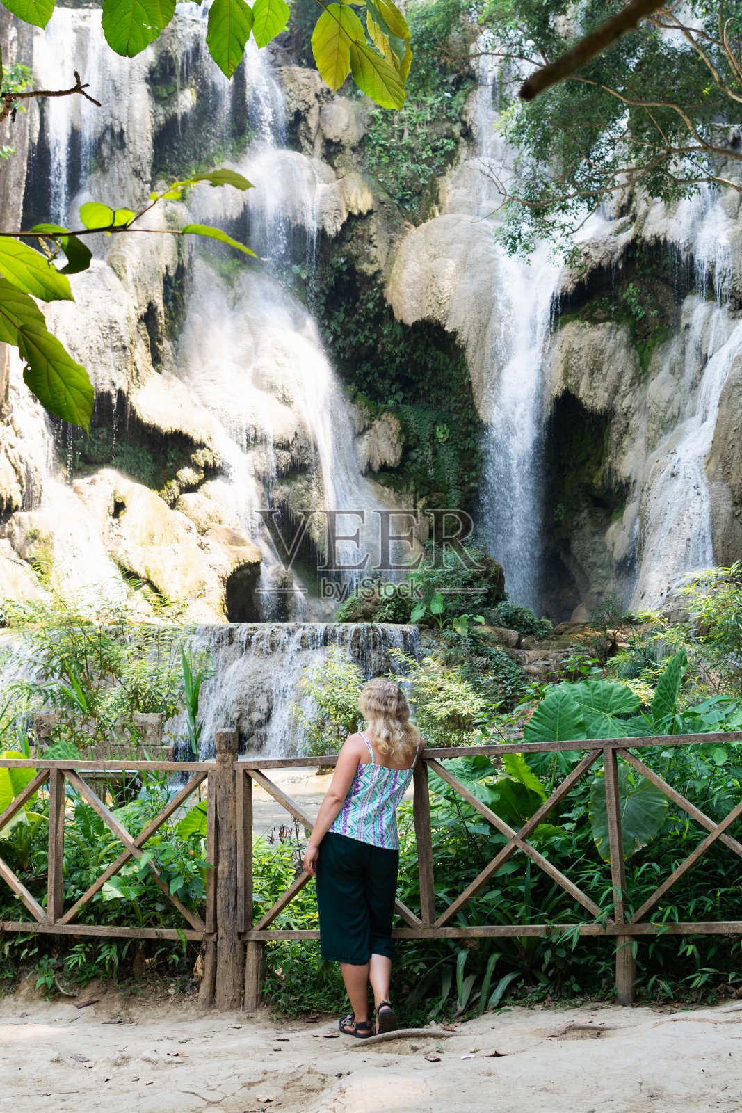 在老挝琅勃拉邦附近，一名女子站在匡斯瀑布前照片摄影图片