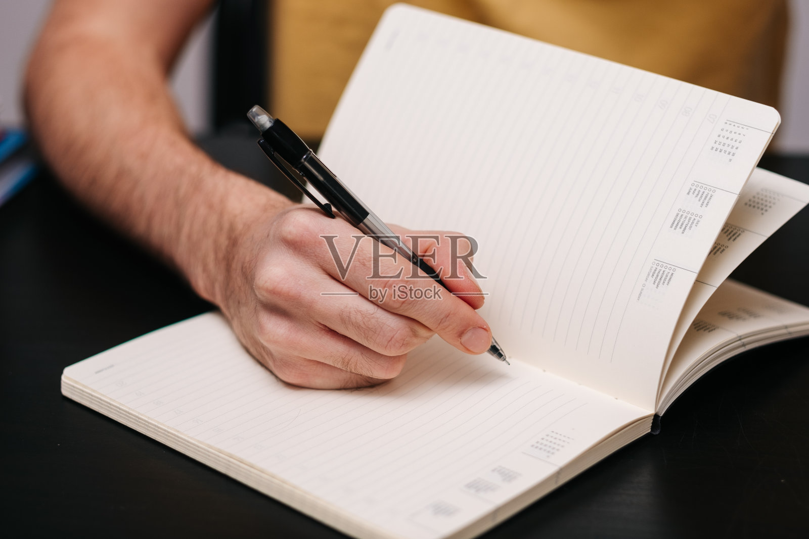 男人用铅笔在笔记本上写字照片摄影图片