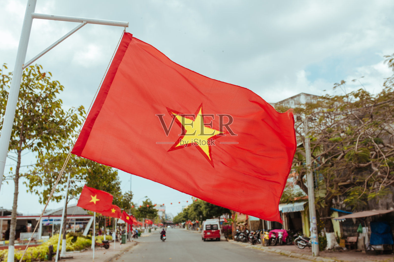 越南国旗在城市街道上迎风飘扬照片摄影图片
