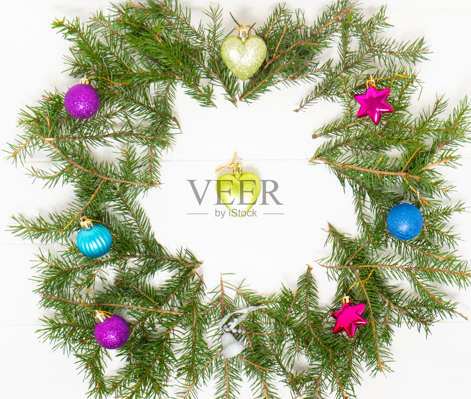 新年的五颜六色的装饰品和圣诞树的树枝放在白色的木制桌子上。照片摄影图片