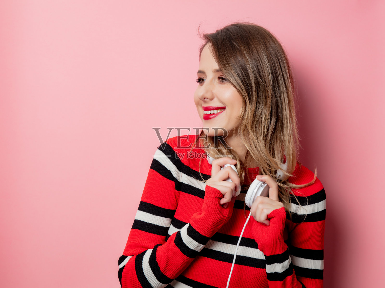穿着条纹毛衣戴着耳机的时尚女性照片摄影图片