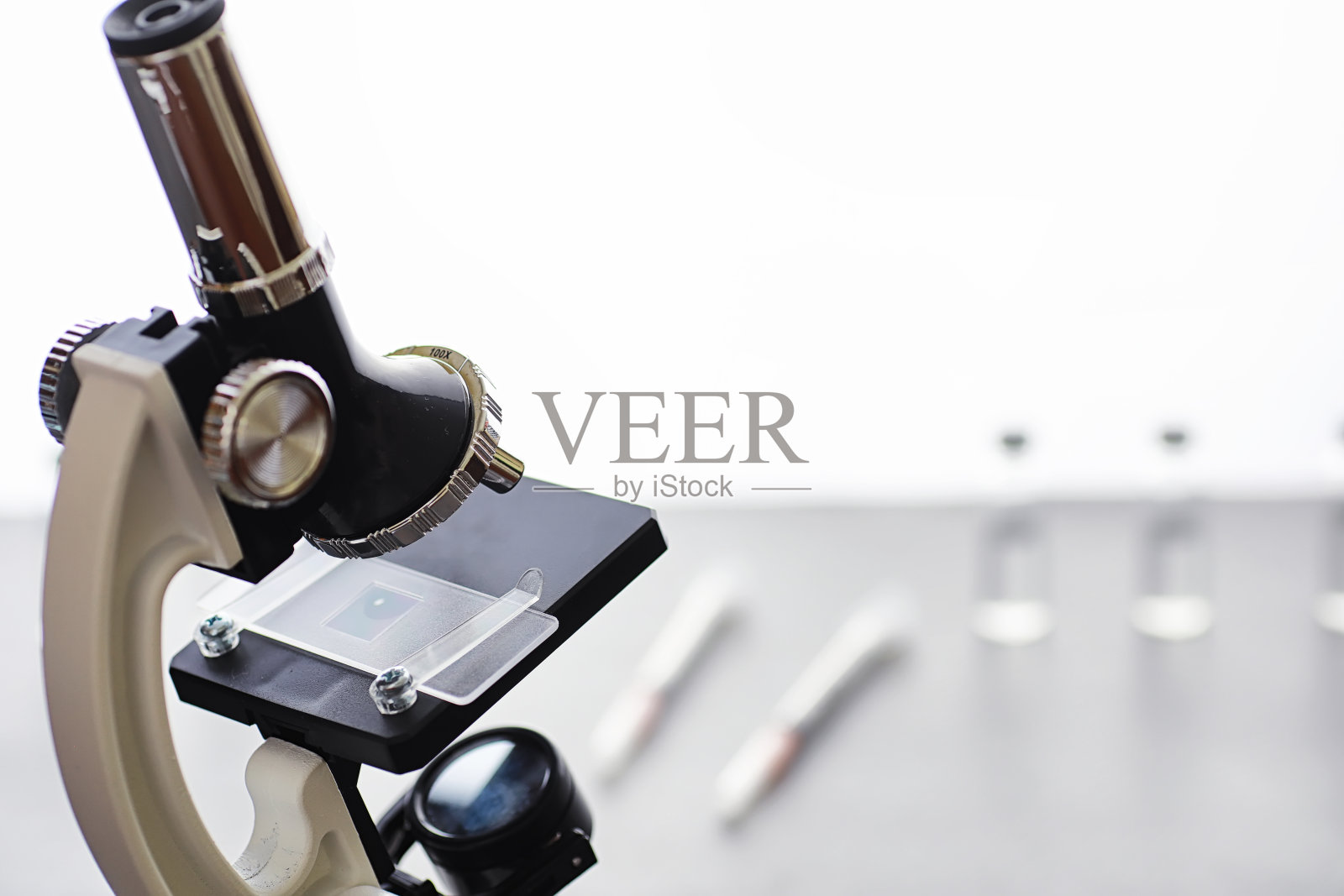 研究实验室。试管和显微镜放在桌子上，白色背景。照片摄影图片