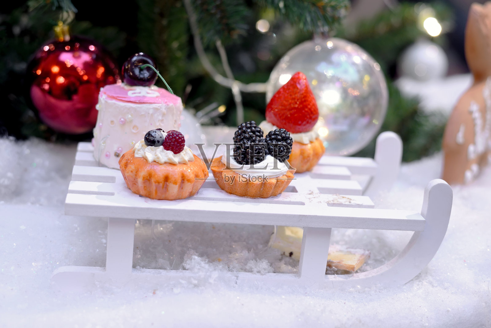 小蛋糕像圣诞玩具放在小雪橇上照片摄影图片