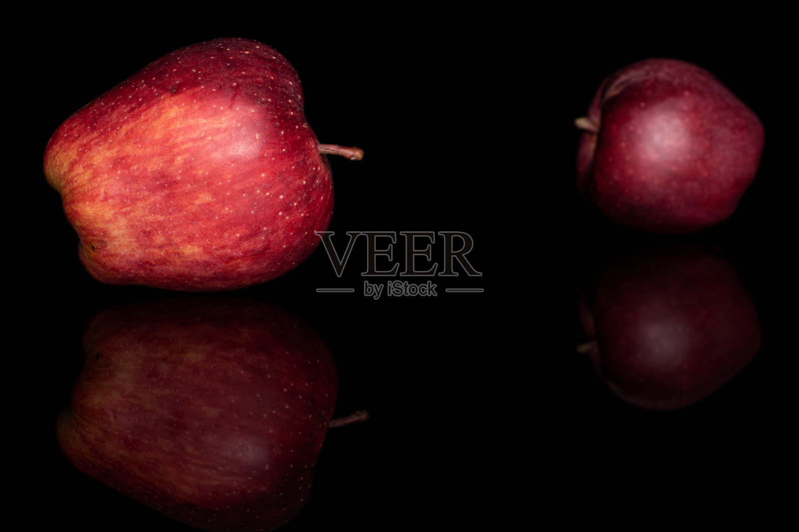 红色美味的苹果孤立在黑色玻璃上照片摄影图片