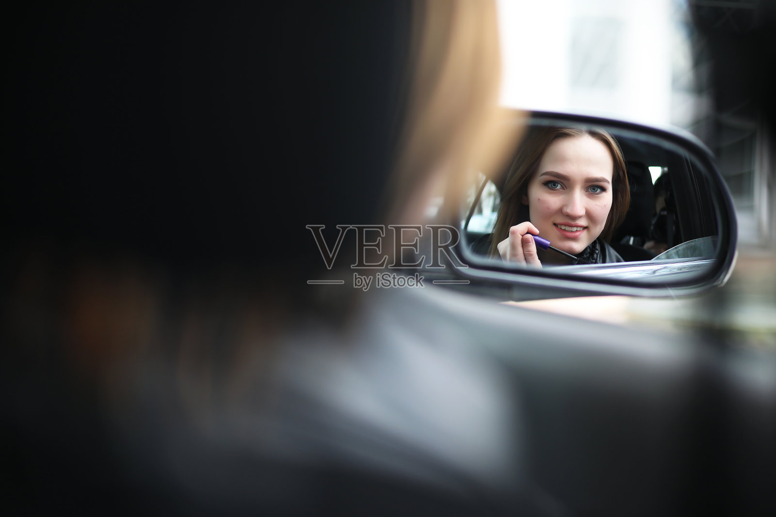 看着后视镜化妆的女孩照片摄影图片