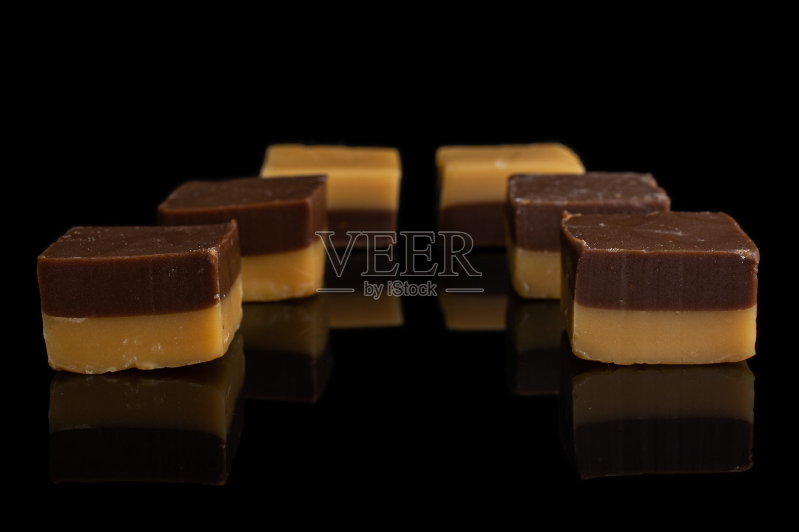 焦糖巧克力糖果孤立在黑色玻璃照片摄影图片