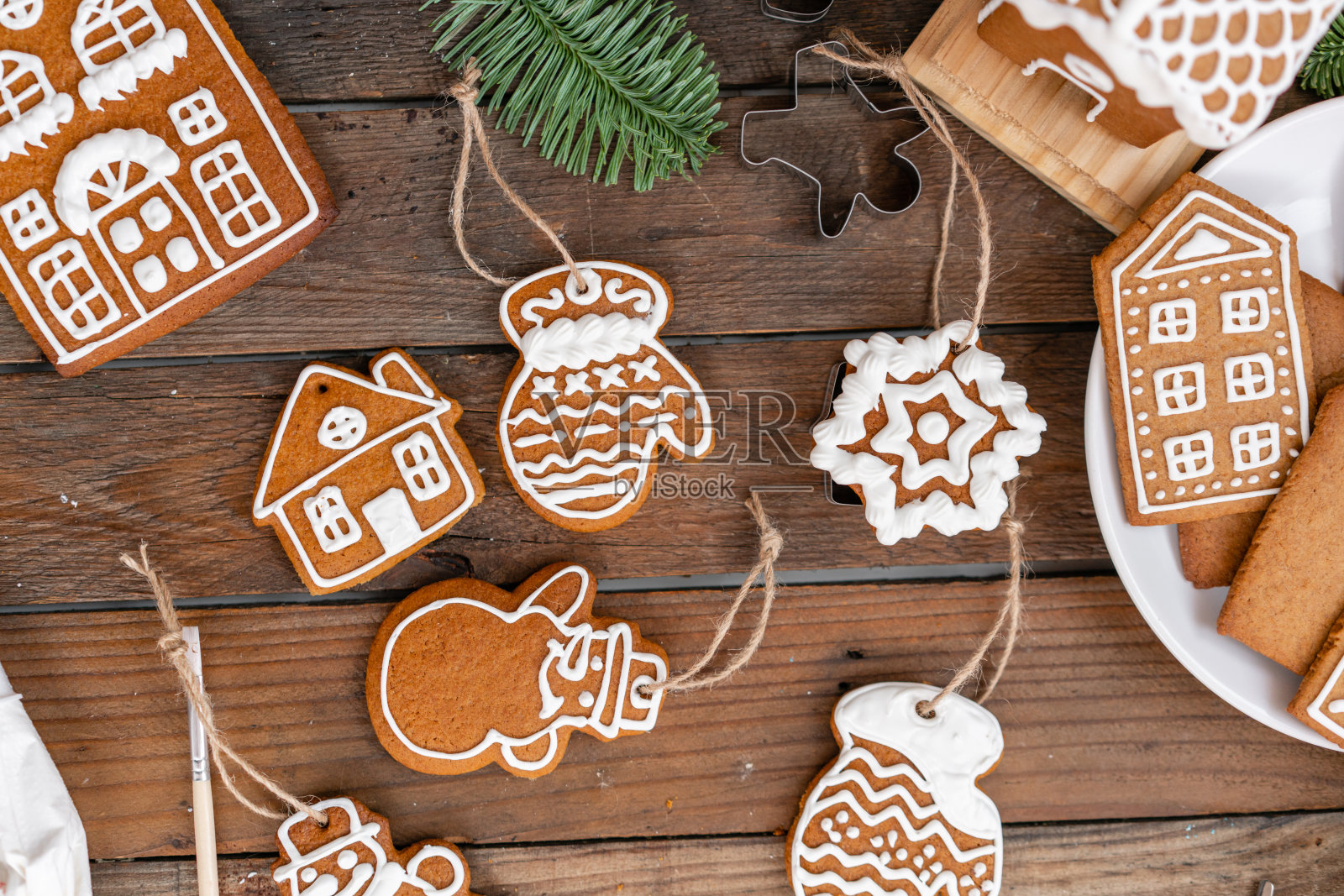 圣诞节自制的姜饼饼干放在木桌上。圣诞蛋糕的糖霜。特写镜头,复制空间。姜饼屋空白饼干，准备装饰。照片摄影图片