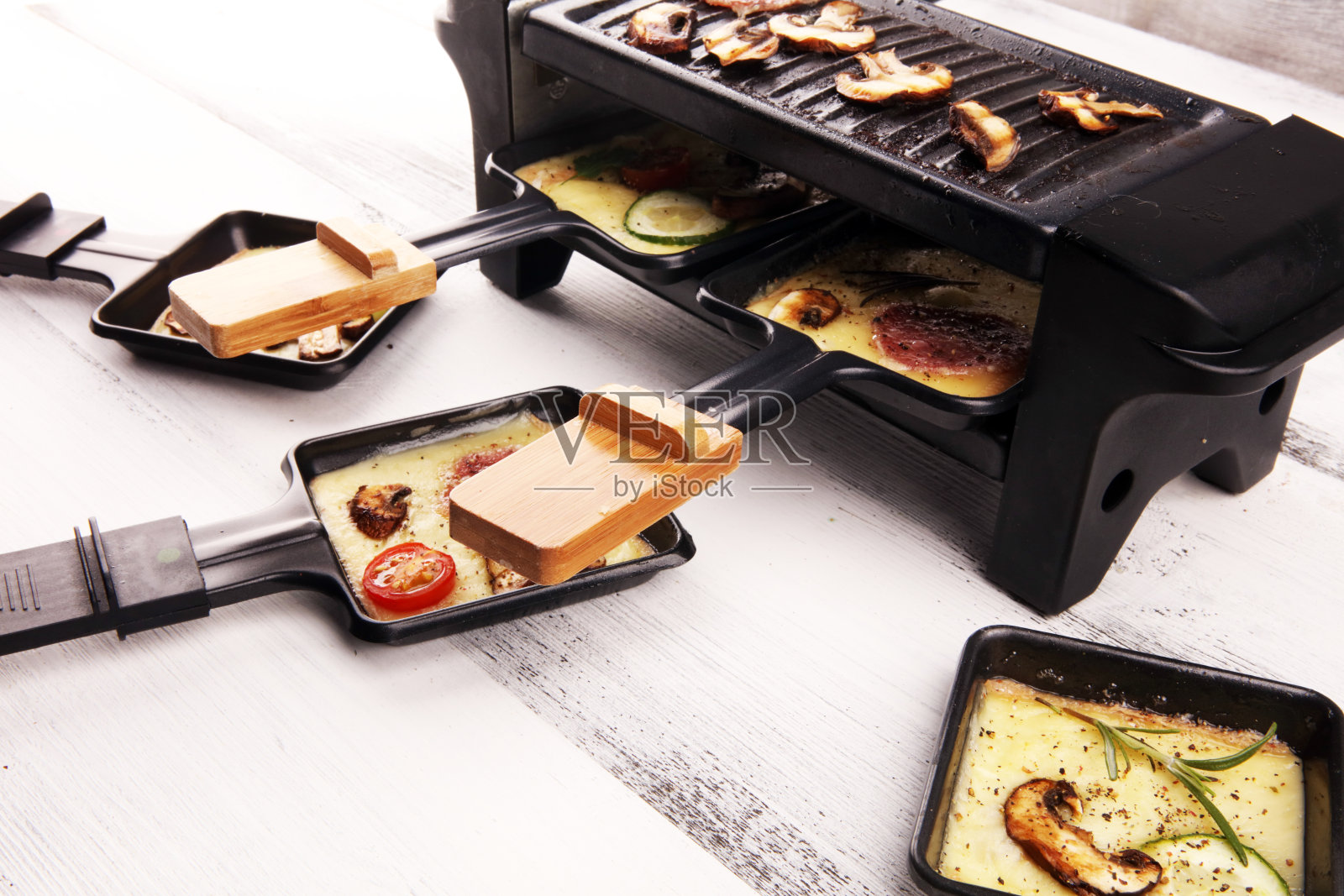 美味的传统瑞士融化raclette奶酪配煮或烤马铃薯丁。照片摄影图片