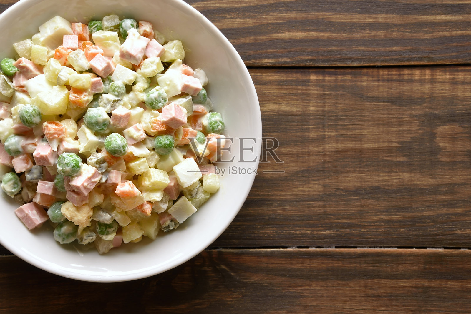 奥利维尔沙拉，由煮熟的蔬菜和香肠加蛋黄酱制成照片摄影图片