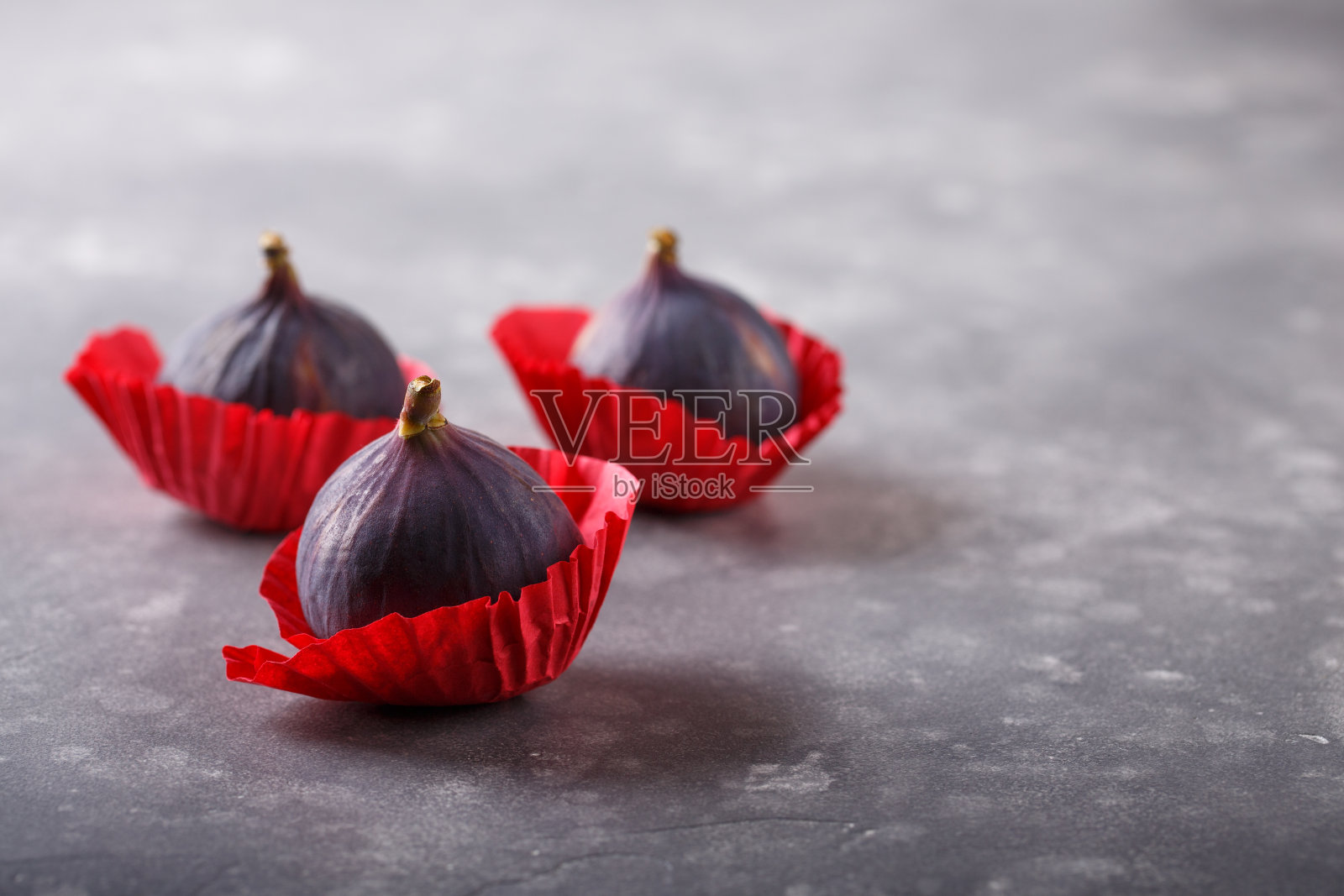 灰色背景上的新鲜紫色无花果。照片摄影图片