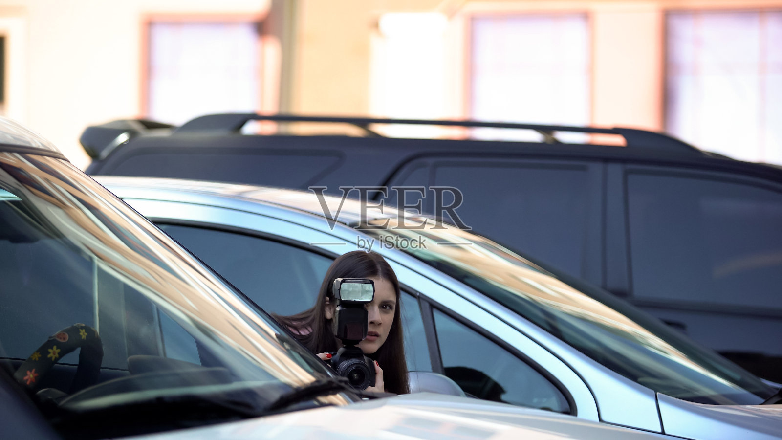 女记者带着相机躲在停车场，寻找刺激照片摄影图片