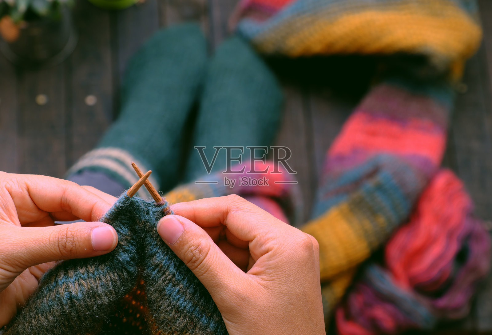 俯瞰坐在家中阳台上的女人，编织彩色羊毛围巾作为有意义的手工冬季礼物照片摄影图片