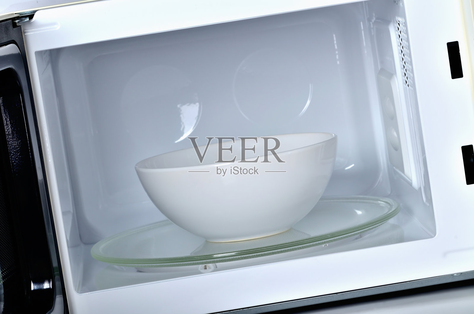 微波炉内部用干净的白色空碗照片摄影图片