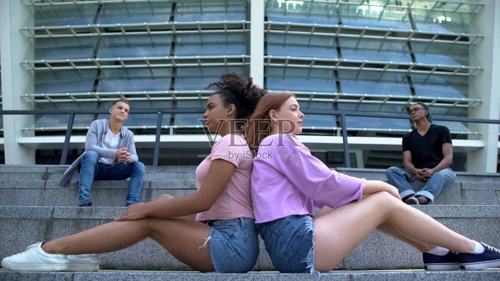 担心的千禧一代背靠背坐在户外，青少年忧郁，问题照片摄影图片