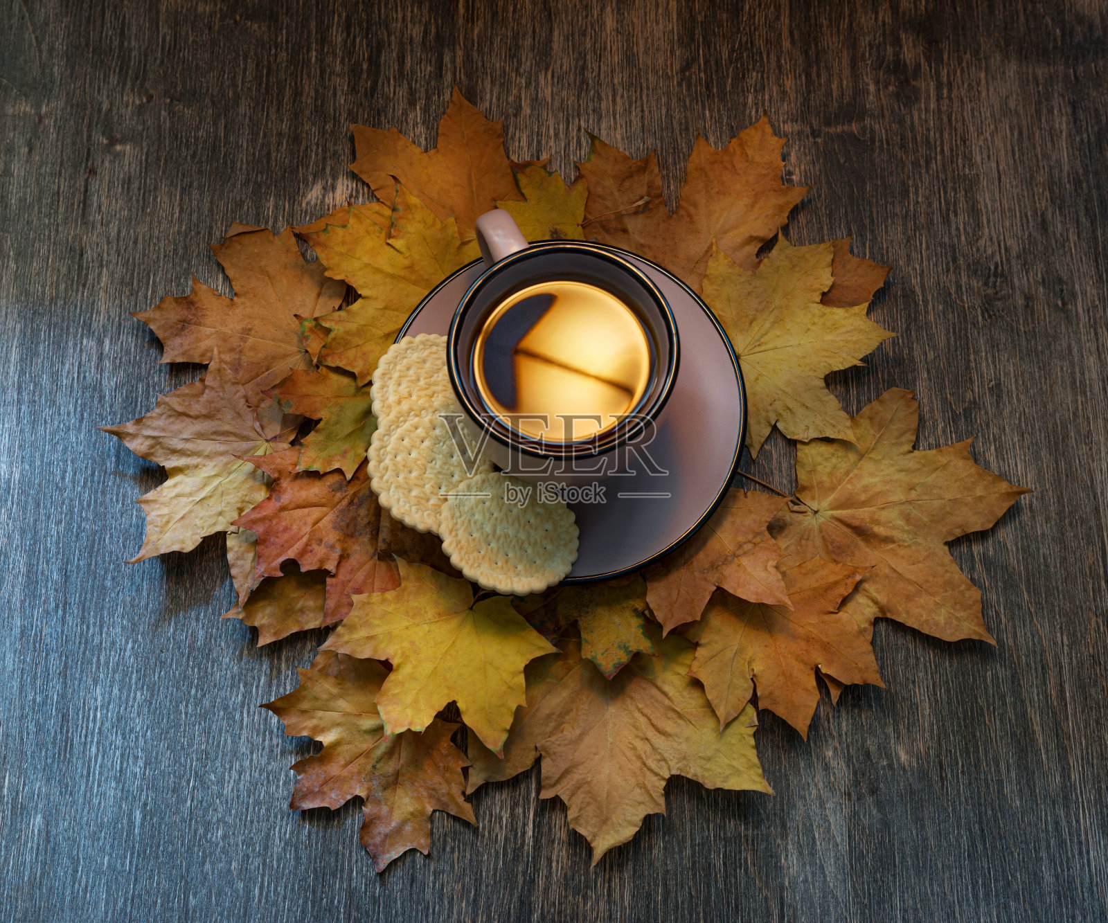 木桌上放着一杯咖啡，背景是秋叶照片摄影图片