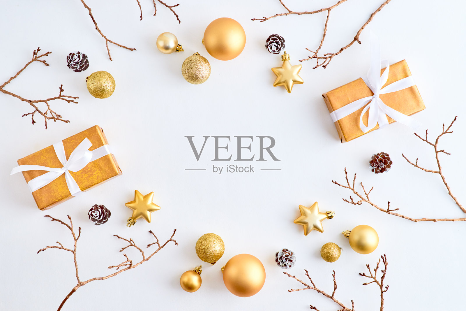 平lay框架与金色的圣诞球，树枝和礼盒在白色的背景照片摄影图片