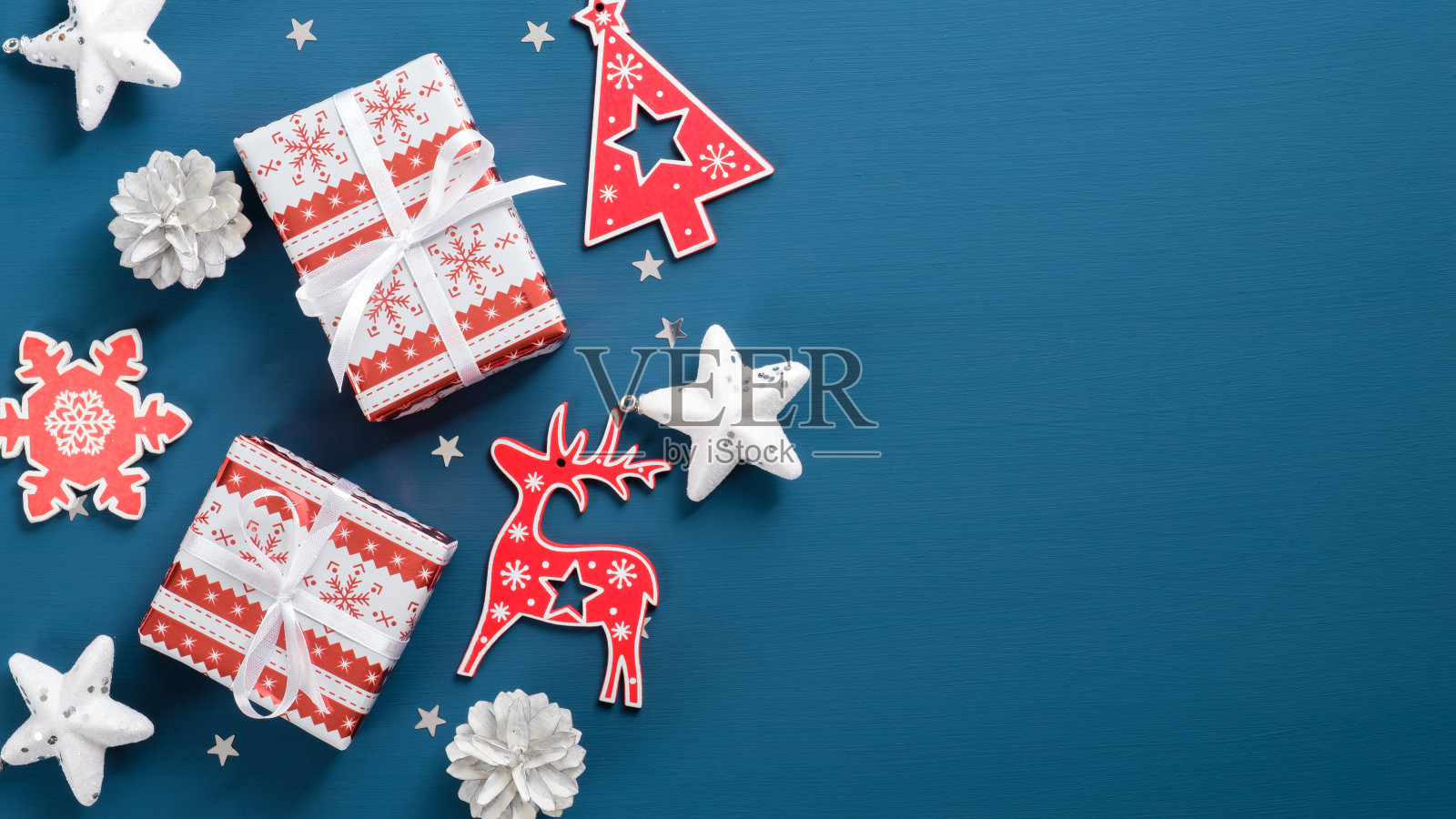 俯视图复古圣诞元素在蓝色背景与复制空间。平铺红白复古风格的圣诞装饰品和礼品盒。圣诞贺卡模板，新年横幅模型。照片摄影图片