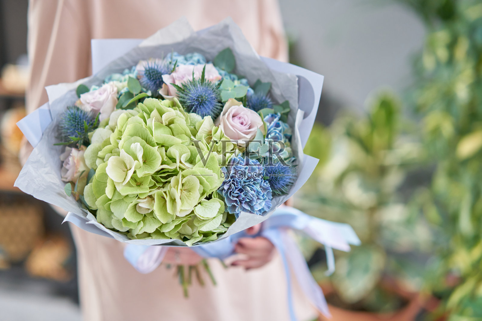 女人手里捧着一束美丽的混合鲜花。花店花匠的工作。英俊的新鲜的花束。鲜花交付照片摄影图片
