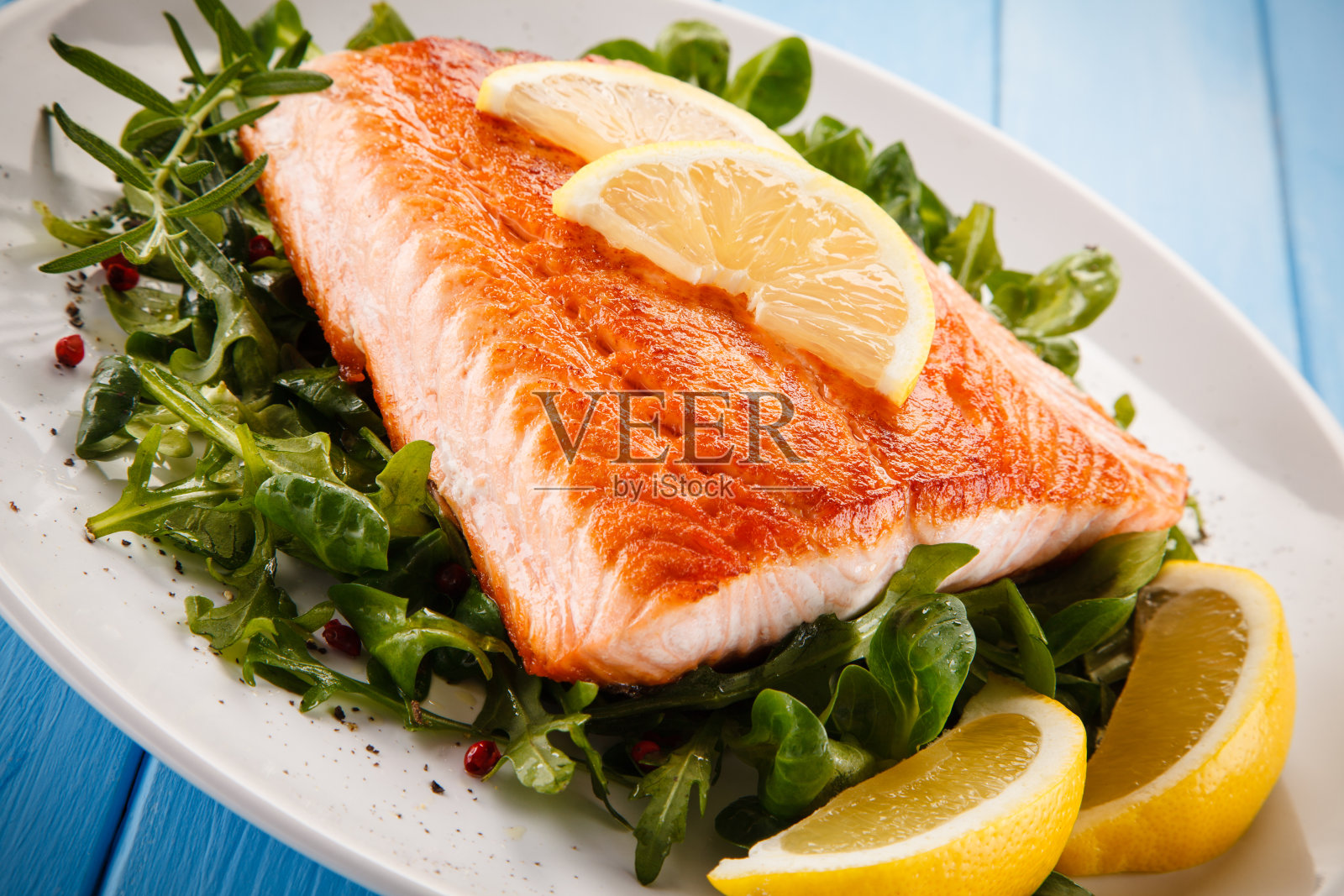 鱼碟——木制背景上的烤鲑鱼和蔬菜照片摄影图片