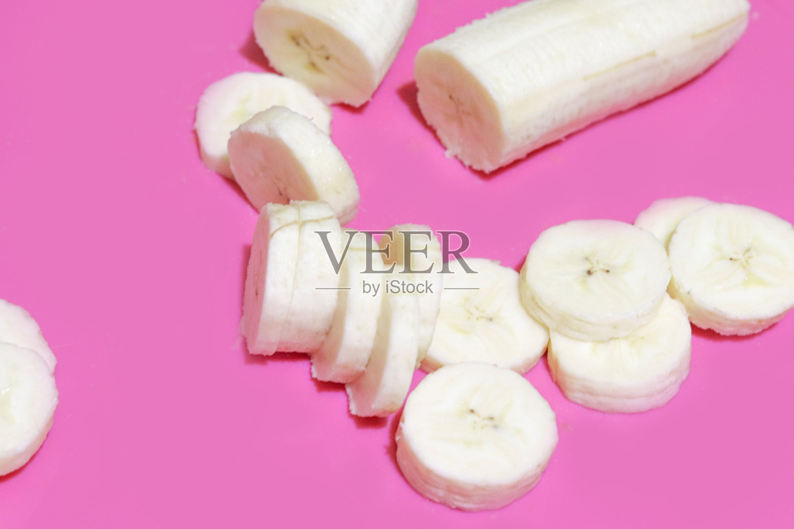 香蕉片顶视图上亮粉色的背景。健康的饮食和生活方式。照片摄影图片