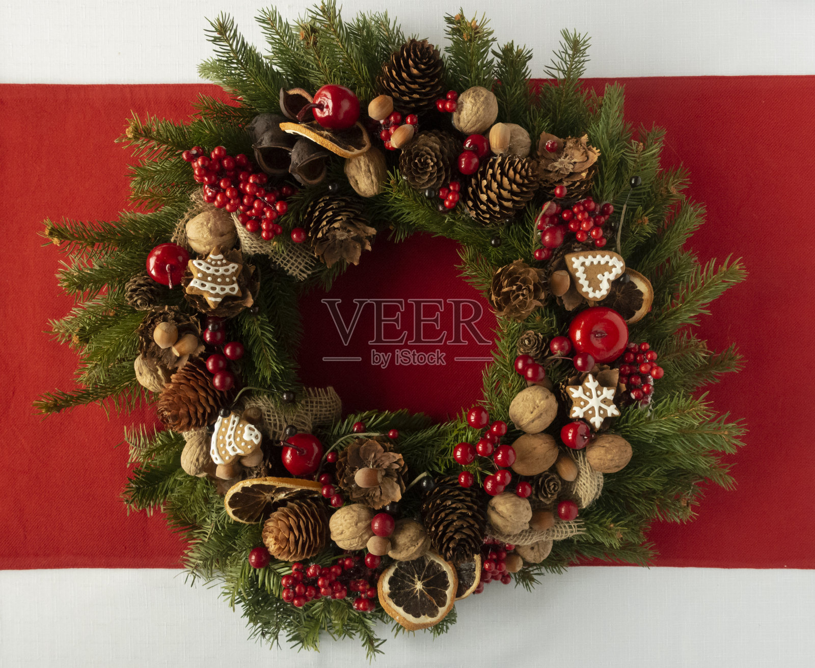 用云杉树枝做成的圣诞装饰花环，上面有干橙子、蜡烛、圆锥形、姜饼。照片摄影图片