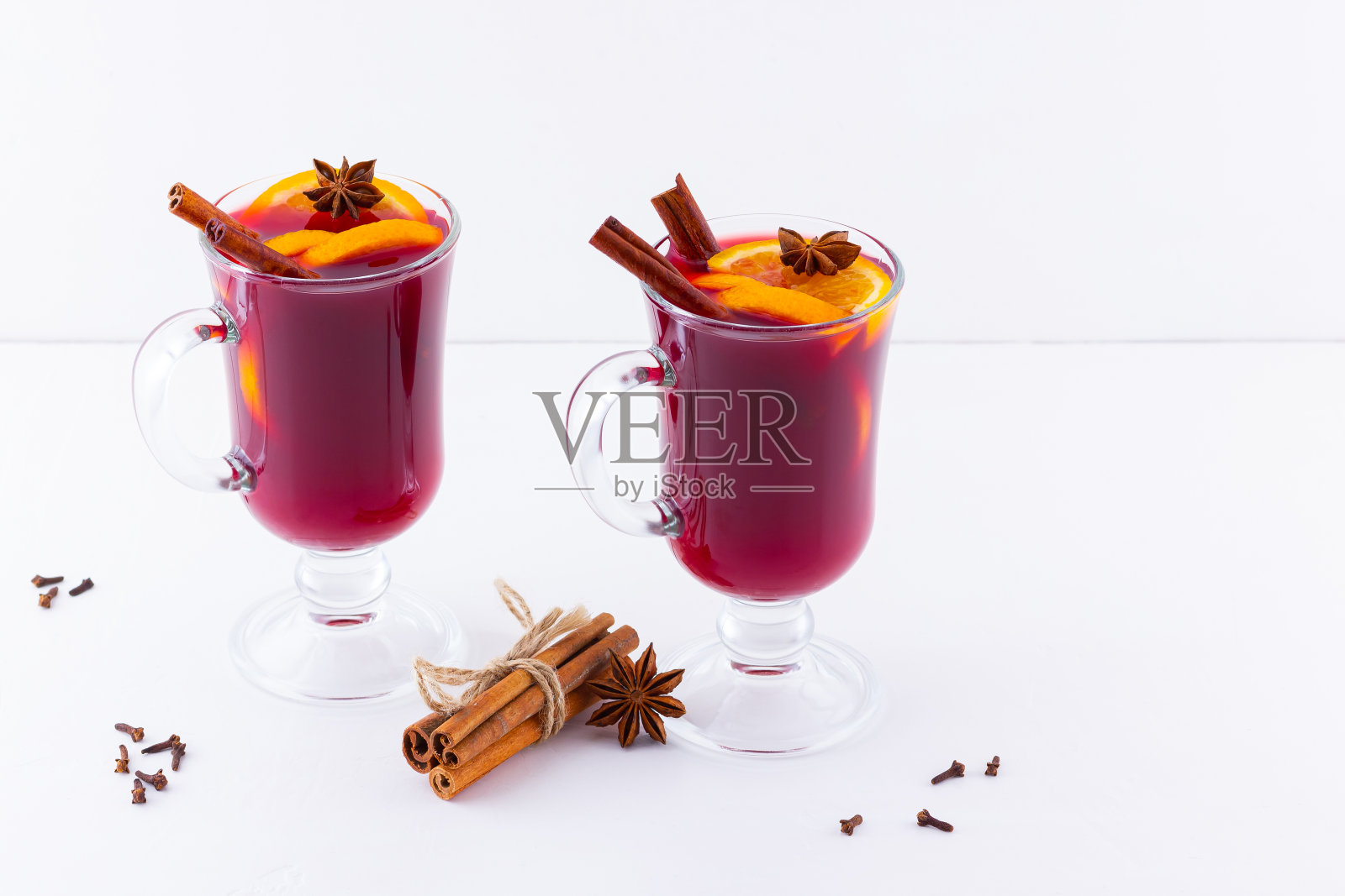 一杯加香料的热葡萄酒。橘子，八角和肉桂的圣诞热葡萄酒。两杯冬季圣诞饮料照片摄影图片