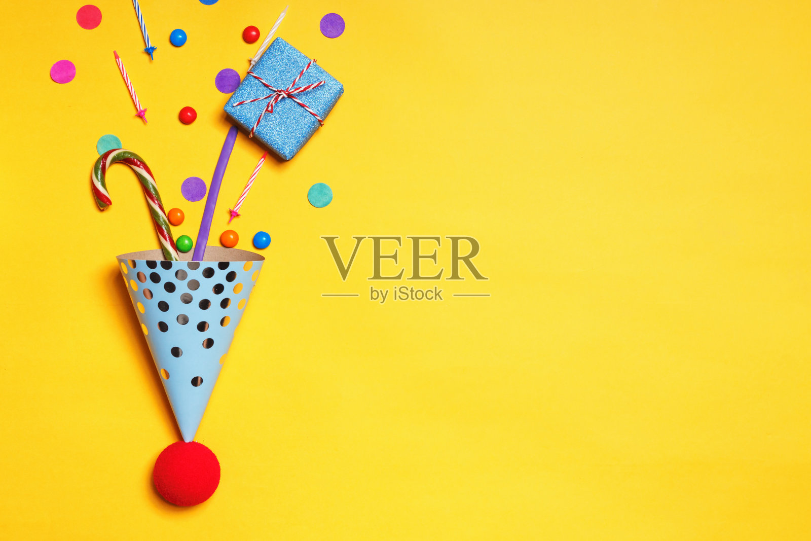 生日黄色背景与派对帽礼物糖果蜡烛与复制空间蛋糕照片摄影图片