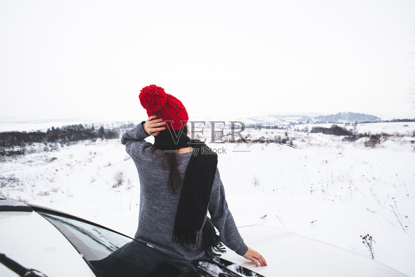 女人坐在suv的引擎盖与美丽的风景。冬天的时间。汽车旅行照片摄影图片