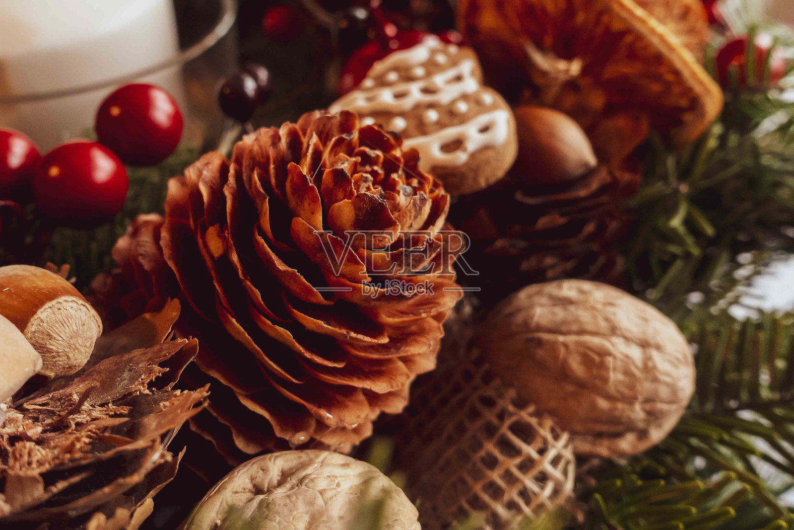 用云杉树枝做成的圣诞装饰花环，上面有干橙子、蜡烛、圆锥形、姜饼。照片摄影图片