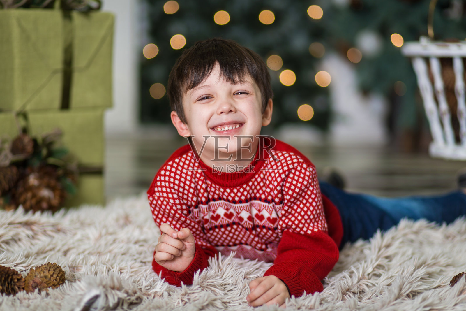圣诞树旁玩松果的小男孩肖像（2020年）照片摄影图片
