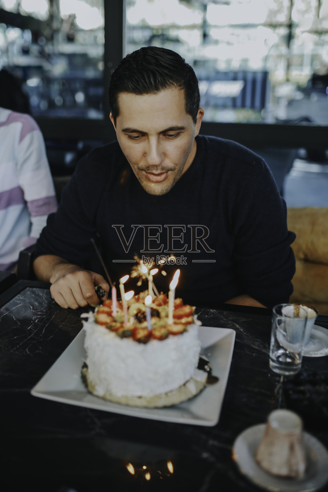 男人吹灭蛋糕上的蜡烛，生日照片摄影图片