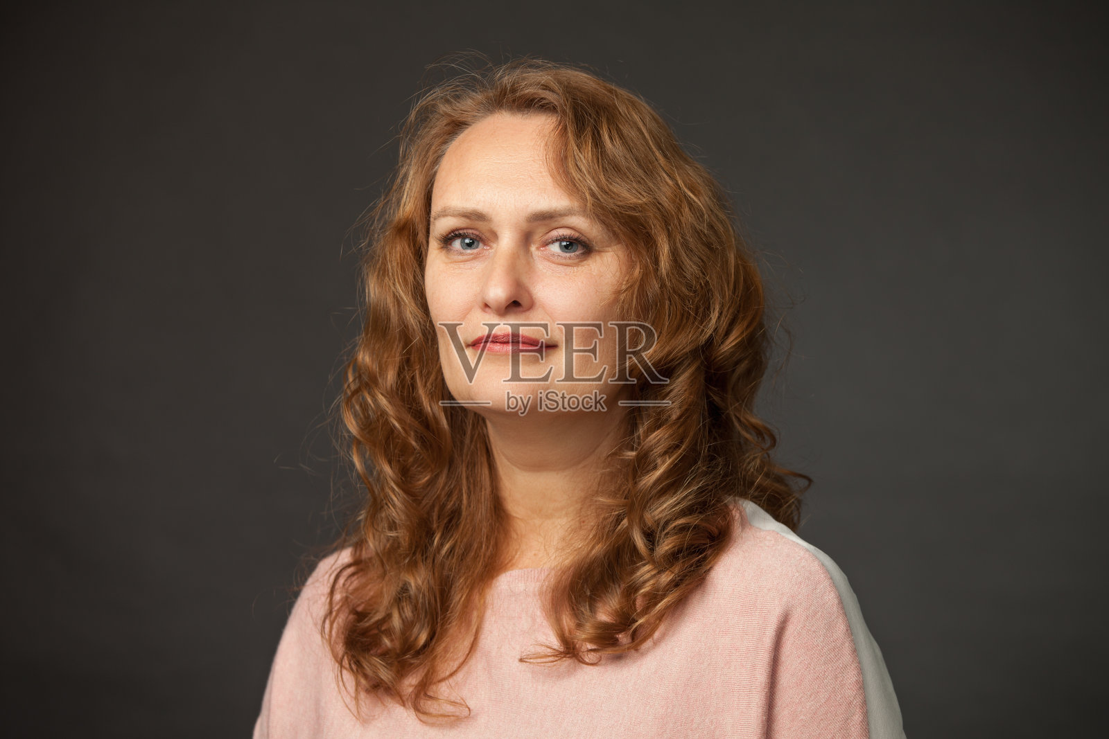 一个50岁的长卷发女人的工作室肖像照片摄影图片