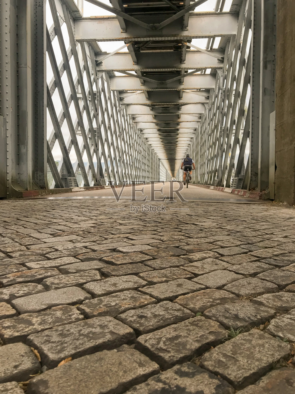 下面是巴伦卡横跨米尼奥河的铁桥，背景是一个骑自行车的人。照片摄影图片