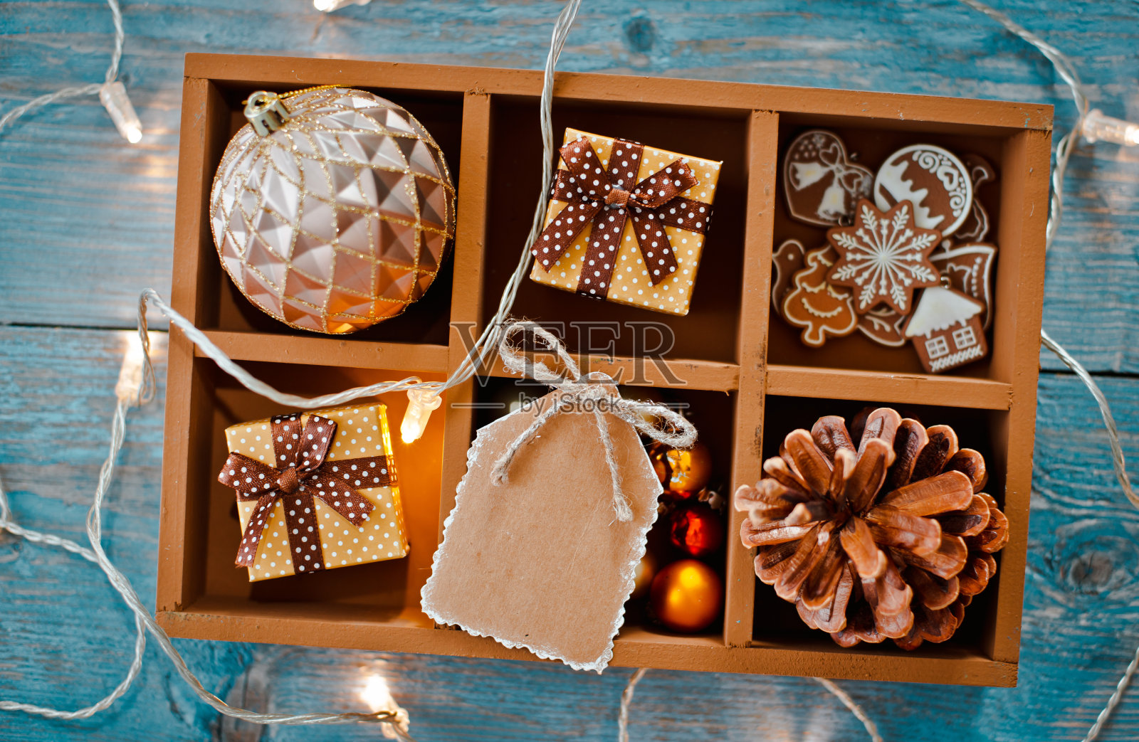 圣诞装饰品是在一个蓝色木制背景的盒子里。照片摄影图片